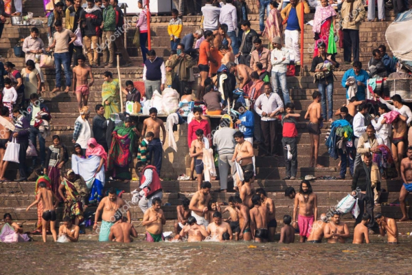 VARANASI, INDIA. February 28, 2017: Crowds of people the stairs of the embankment of the river Ganges, Varanasi, India. Hindus brush their teeth washed in the river.